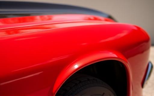 Shiny red car parked outside, highlighting paint gloss